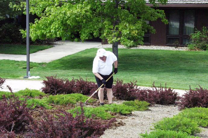 Student working the gardens around Ward Bell Tower.